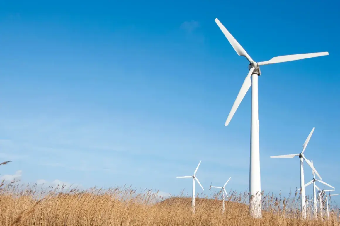 Wiatraki na tle błękitnego nieba. To przykład OZE, czyli odnawialnych źródeł energii, które wykorzystują siłę wiatru do produkcji prądu.